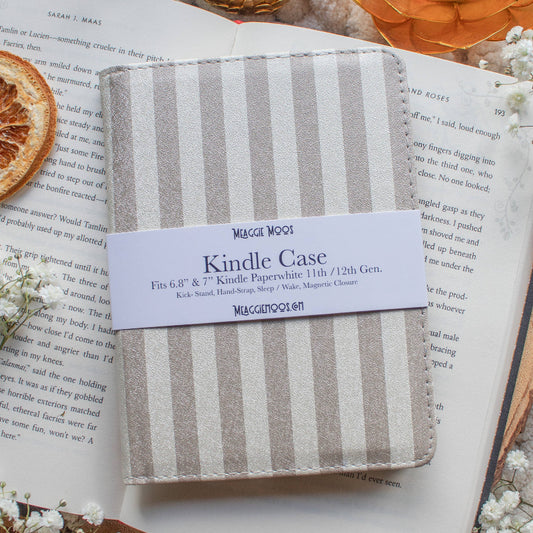 Kindle case with striped design on an open book surrounded by decorative elements