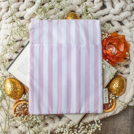 Pink striped fabric pouch on a textured surface with flowers and gold eggs.