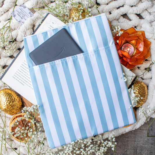 Blue and white striped pouch with a phone case on a textured surface with decorative elements.