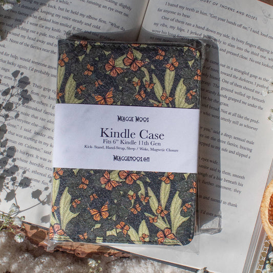 Butterfly -print Kindle case on an open book with dried oranges and flowers