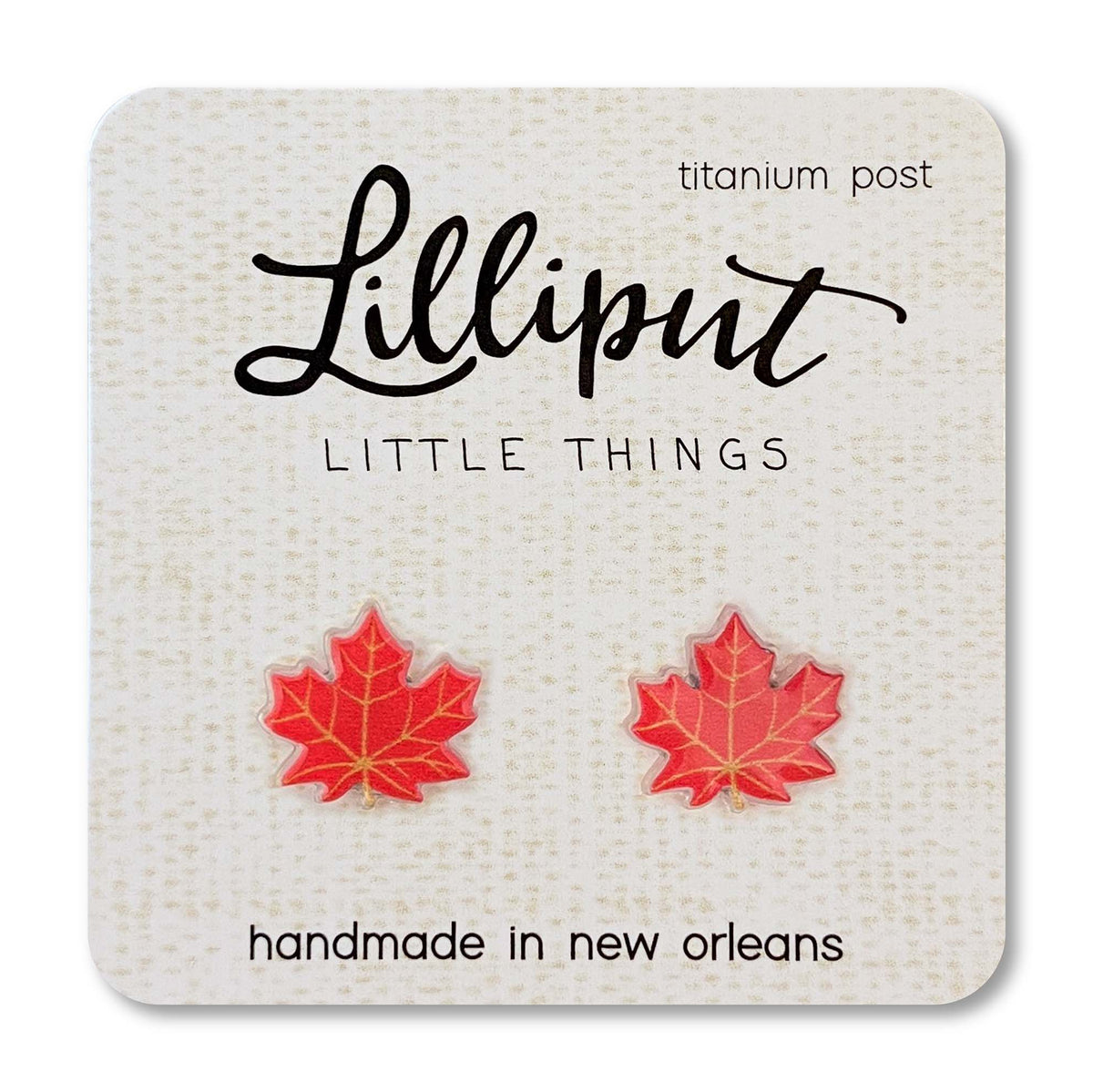 Red maple leaf earrings on a Lilliput Little Things branded card.