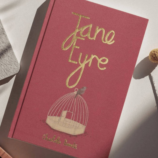 Red book titled 'Jane Eyre' with a birdcage illustration on a white surface