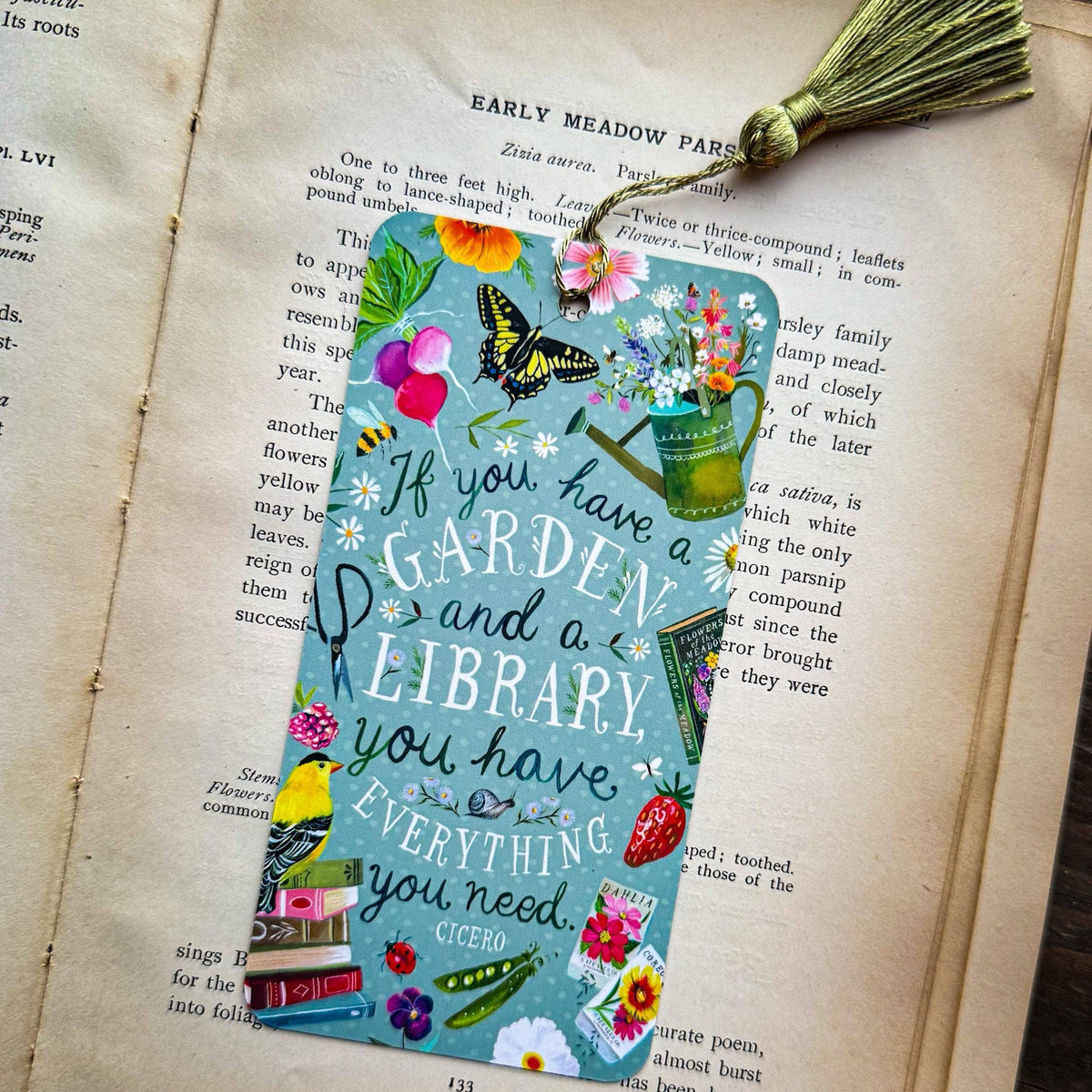 Colorful bookmark with garden and library quote on an open book
