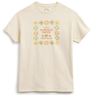 An off-white short-sleeve crewneck t-shirt featuring a retro-style graphic on the chest with a floral border and the text 'PUMPKIN PATCH BOOK CLUB'.