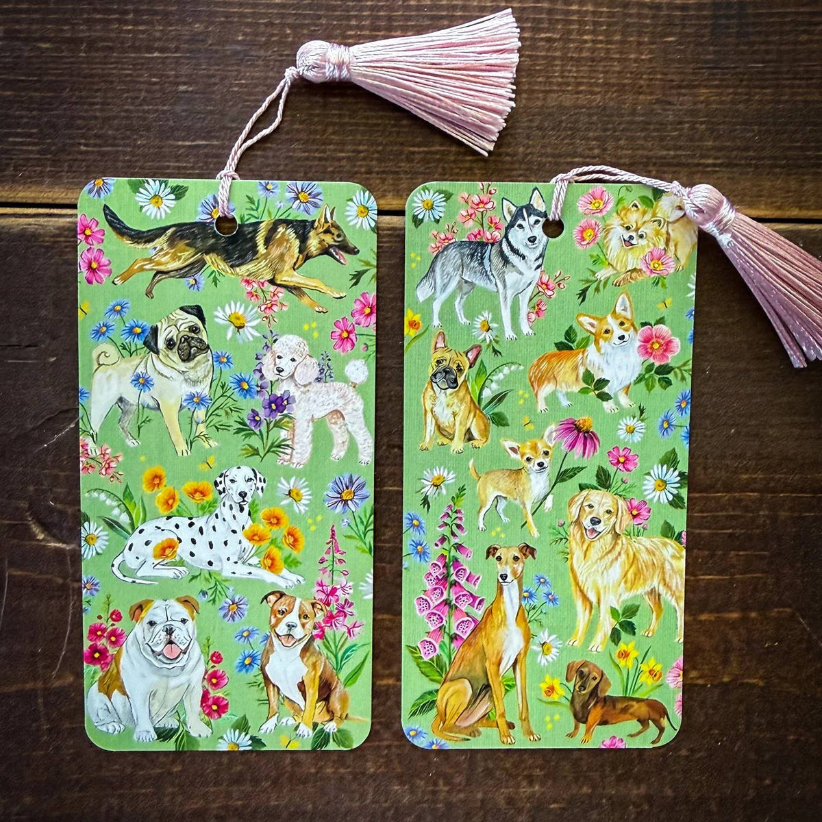 Two decorative bookmarks with dog illustrations on a wooden surface