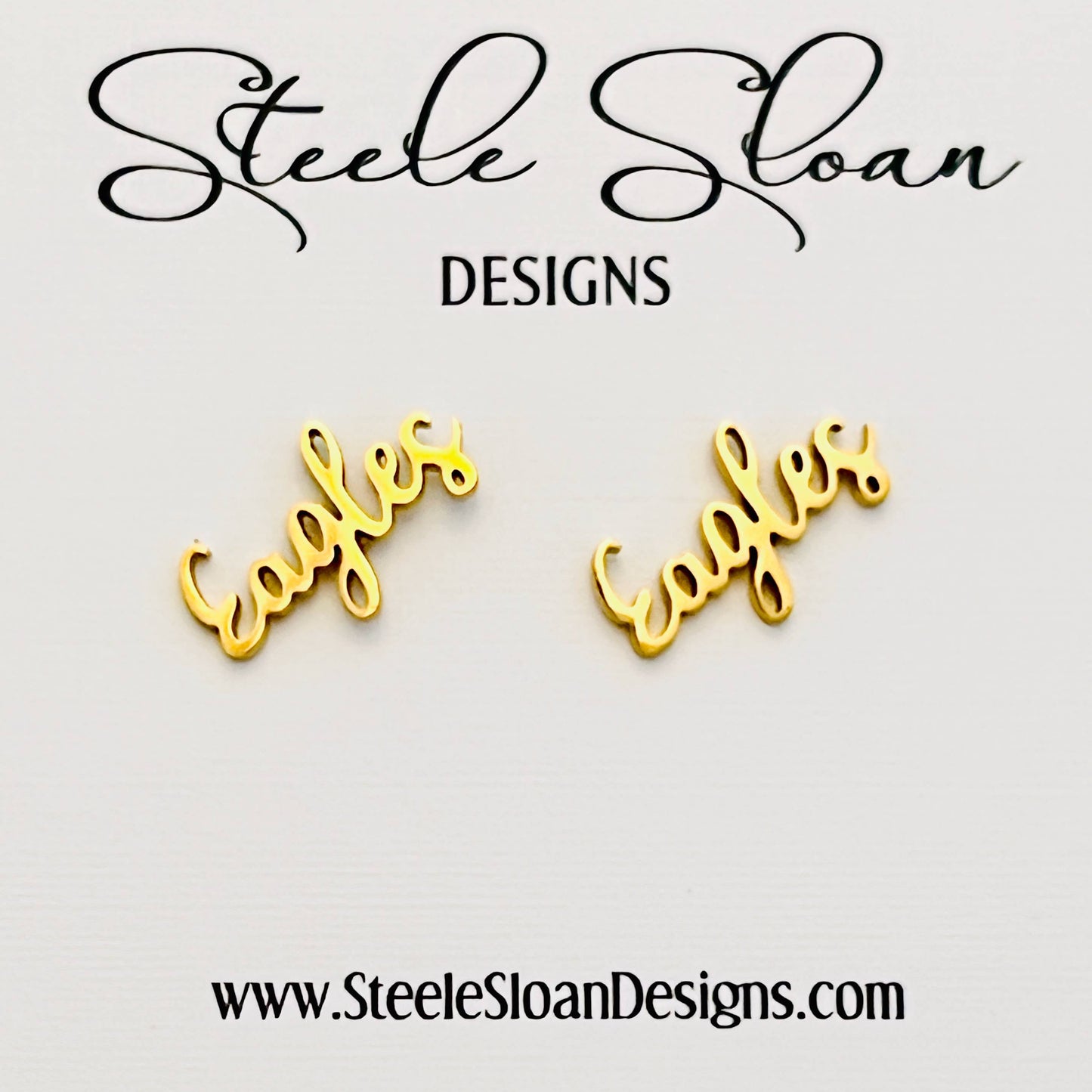 Gold 'Eagles' earrings with 'Steele Sloan Designs' branding on a light gray background.